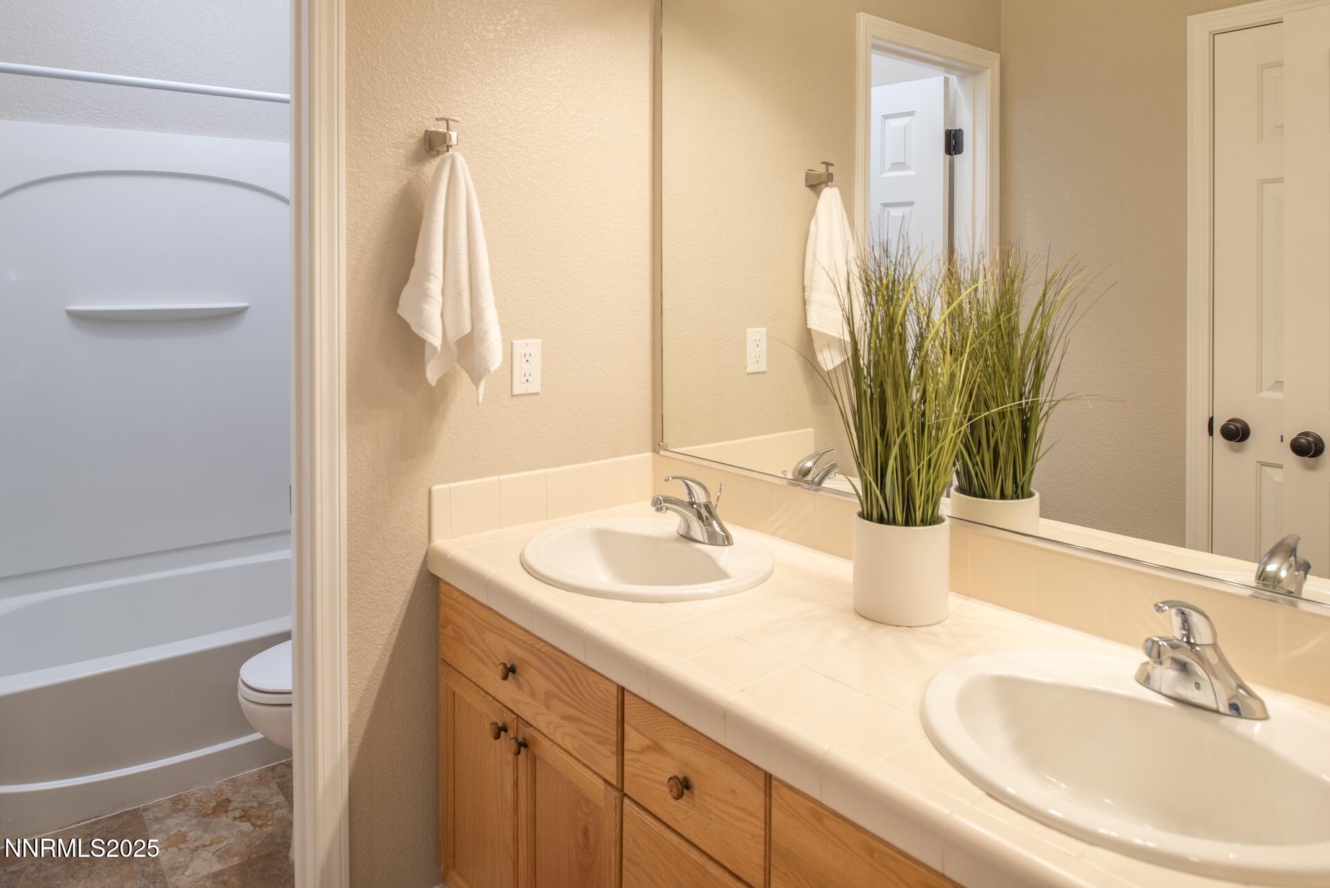 9579 Mammoth Court Reno, NV 89521 - Photo 20 of 39 a bathroom with a double vanity sink and a mirror