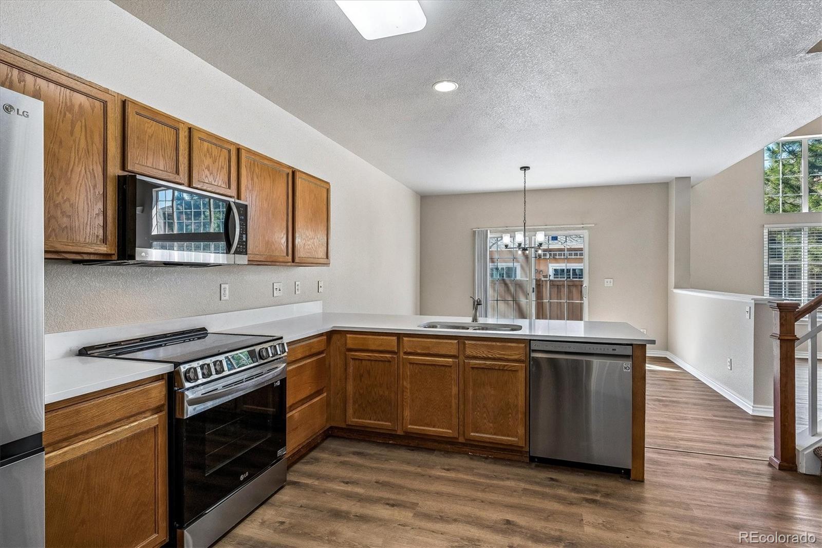 4545 South Taft Way Morrison, CO 80465 - Photo 12 of 24 a kitchen with stainless steel appliances granite countertop a stove a sink and a microwave