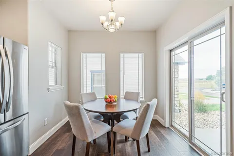 a view of a dining room with furniture large window wooden floor and a chandelier
