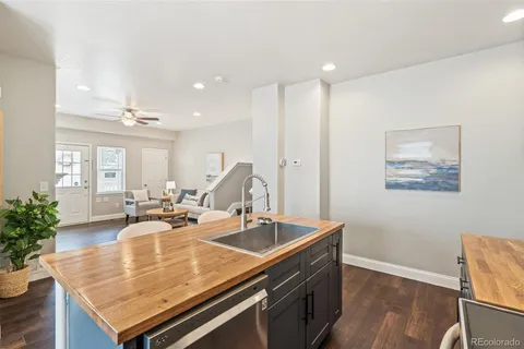 a room with stainless steel appliances kitchen island granite countertop a sink and cabinets