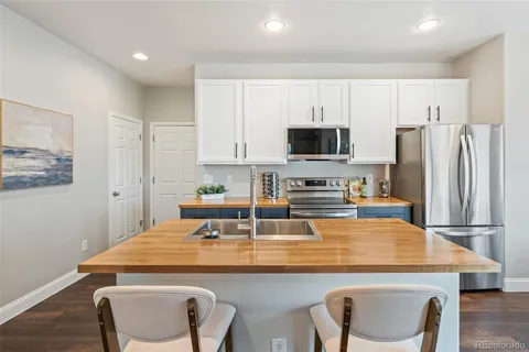 a kitchen with kitchen island a refrigerator stove and microwave