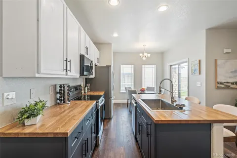 a kitchen with stainless steel appliances granite countertop a sink a stove and a refrigerator