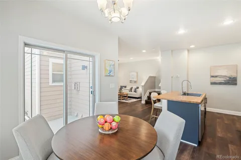 a view of a dining room with furniture a chandelier and wooden floor