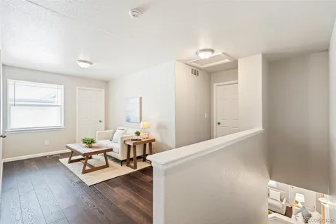 a living room with furniture and wooden floor