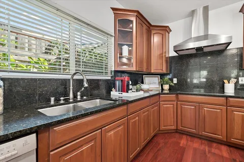 a kitchen with stainless steel appliances granite countertop a sink and wooden cabinets