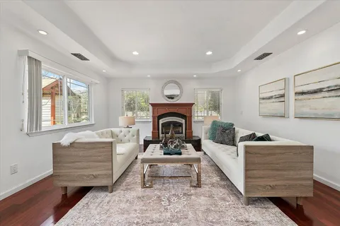 a living room with furniture a fireplace and a wooden floor