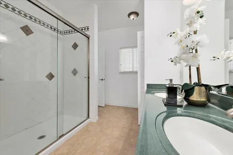 a bathroom with a granite countertop sink a mirror and shower