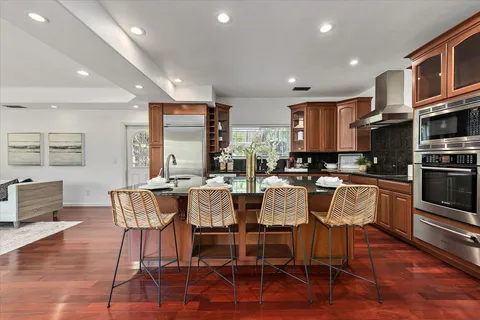 a dining room with stainless steel appliances kitchen island granite countertop a dining table chairs and view living room