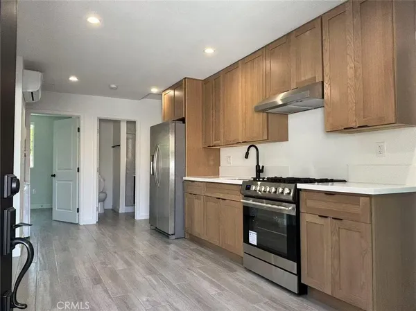 a kitchen with stainless steel appliances a stove a sink and a refrigerator