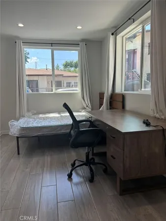 a view of a workspace with furniture and a window