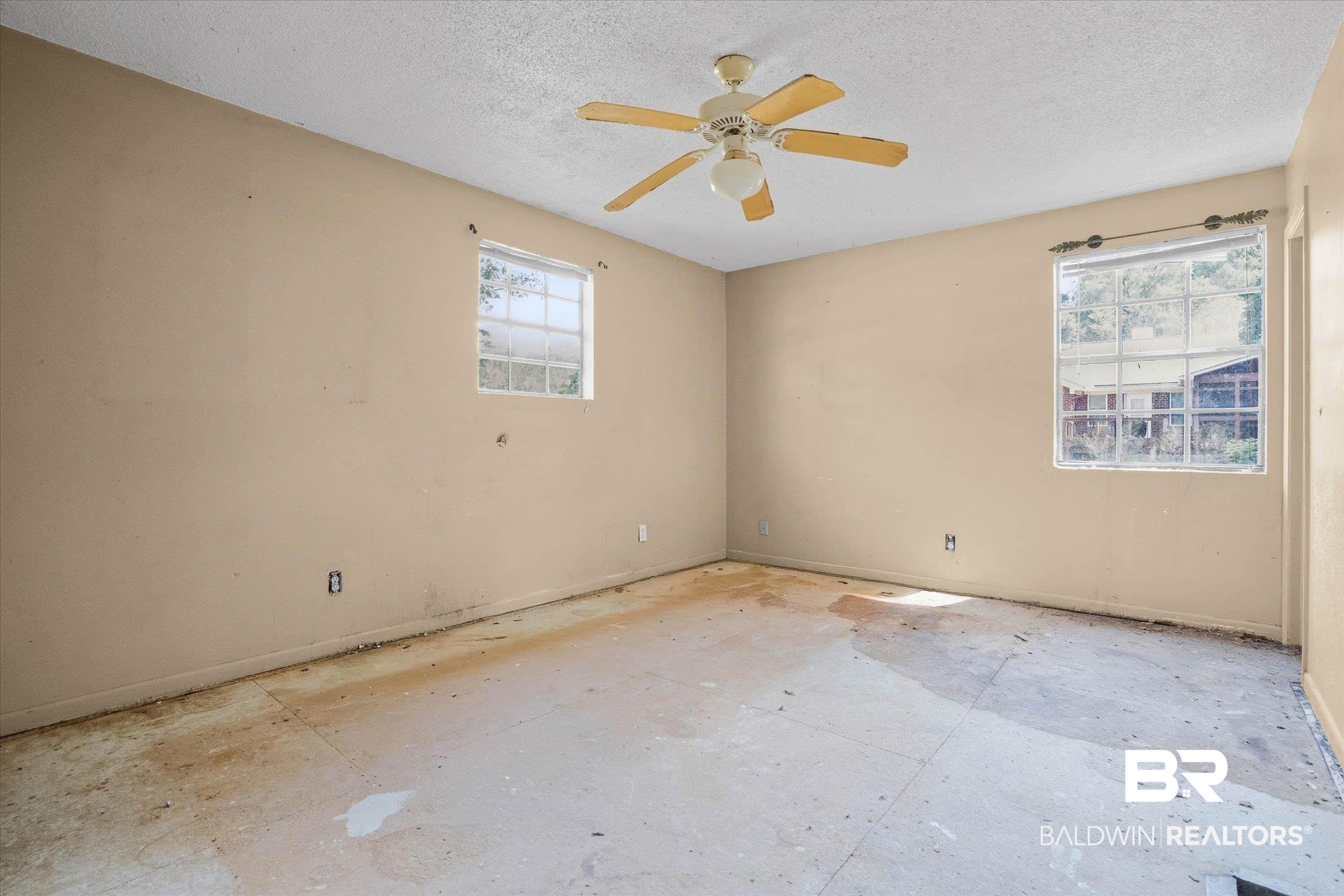 401 Frederick Avenue Fairhope, AL 36532 - Photo 8 of 36 Neutral tone walls with two windows and a ceiling fan