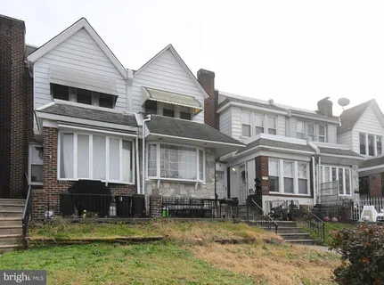 a view of a white house with large windows and a yard