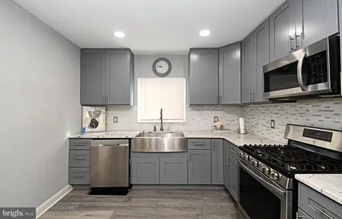 a kitchen with stainless steel appliances granite countertop a sink stove a microwave and cabinets