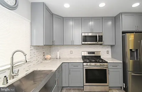 a kitchen with a sink stove and refrigerator