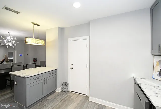 a kitchen with a sink a counter space and wooden floor