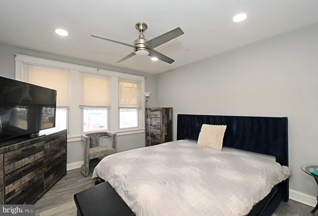 a bedroom with a large bed and a flat tv screen on dresser