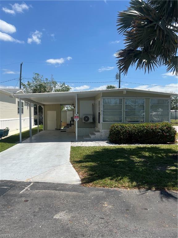 777 Walkerbilt Road, Unit 9 Naples, FL 34110 - Photo 1 of 17 a front view of a house with a garden and yard
