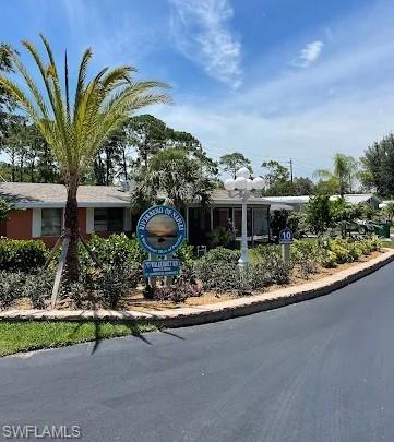 777 Walkerbilt Road, Unit 9 Naples, FL 34110 - Photo 12 of 17 a front view of a house with a yard and potted plants