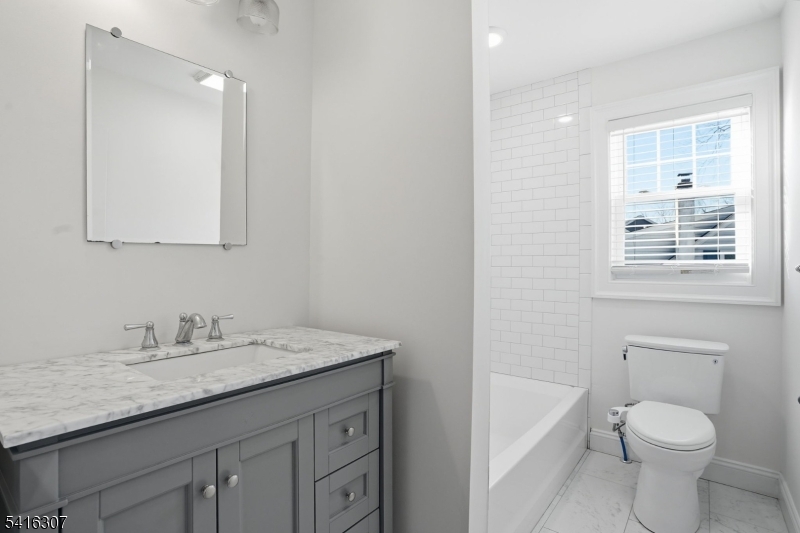 44 Manor Road Livingston, NJ 07039 - Photo 34 of 48 a bathroom with a granite countertop sink a toilet and a bathtub