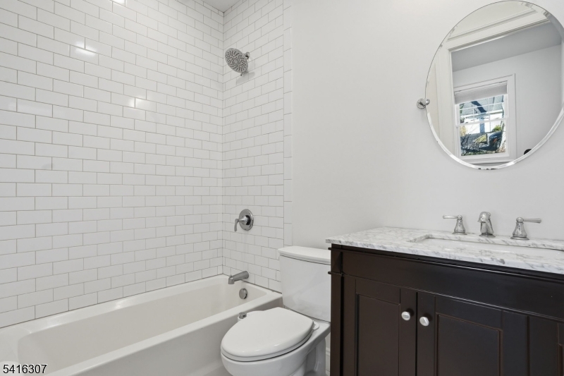 44 Manor Road Livingston, NJ 07039 - Photo 38 of 48 a bathroom with a bathtub a sink a toilet and a mirror