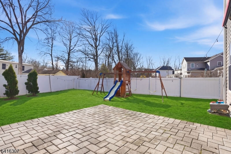 44 Manor Road Livingston, NJ 07039 - Photo 42 of 48 a view of a backyard with plants and a slide