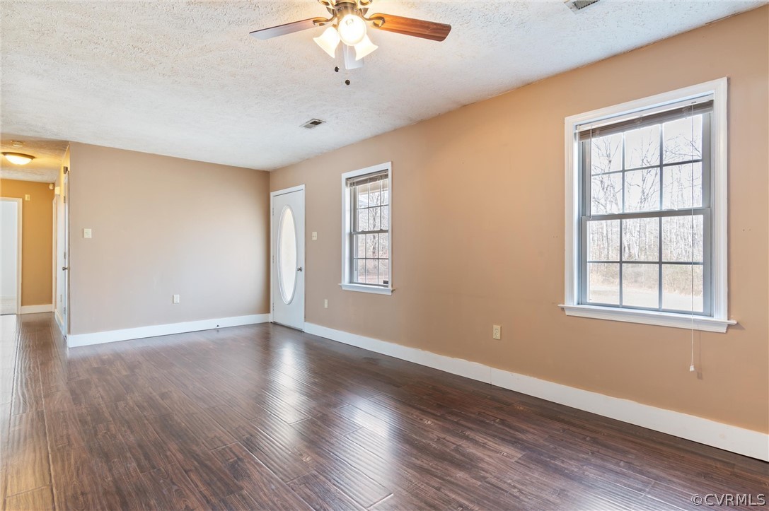 3165 Sandy Hook Road Sandy Hook, VA 23153 - Photo 3 of 25 an empty room with wooden floor chandelier fan and windows