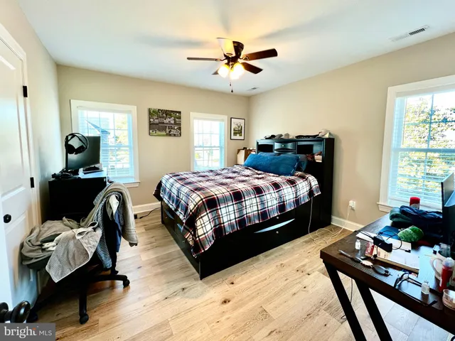 a bedroom with a bed and wooden floor