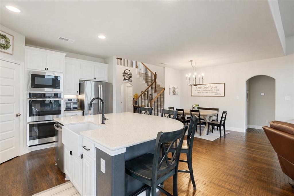 1205 Redbud Street Howe, TX 75459 - Photo 11 of 40 a kitchen with a table chairs and a refrigerator