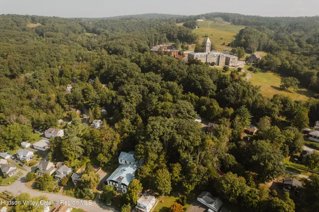 an aerial view of residential house with parking and trees