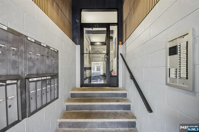 a view of staircase with lots of frames on wall and a window