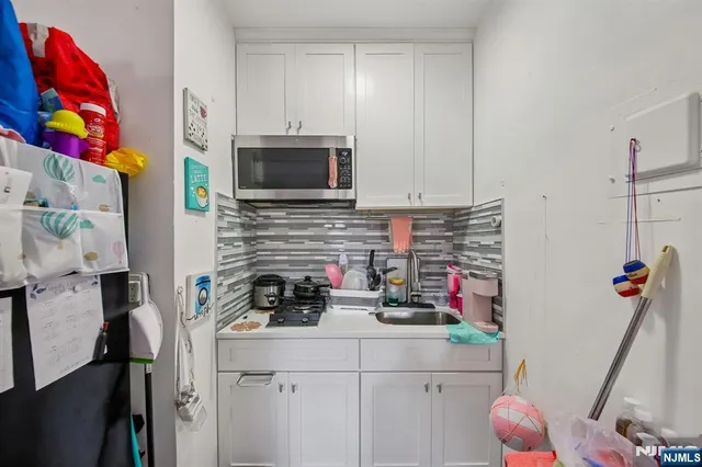 a kitchen with a sink dishwasher refrigerator and microwave with wooden floor
