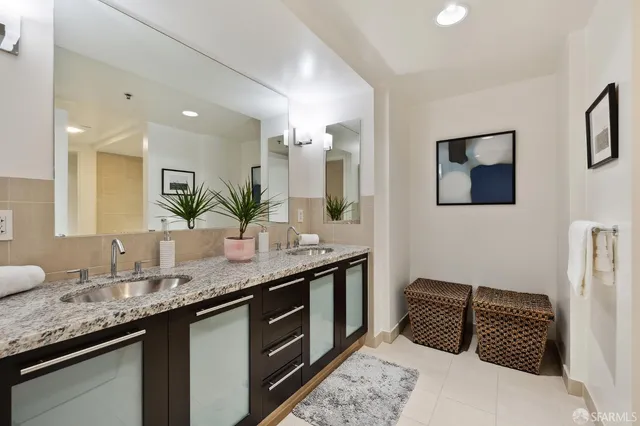a bathroom with a granite countertop sink and a mirror
