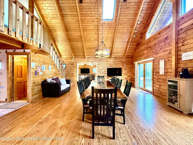a view of a dining room with furniture a chandelier and wooden floor