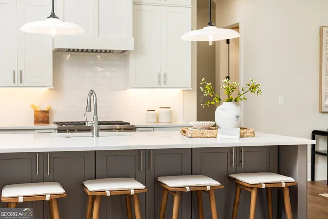 a kitchen with stainless steel appliances a table and chairs in it