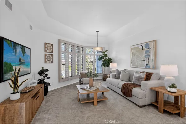 a living room with furniture potted plant and kitchen view