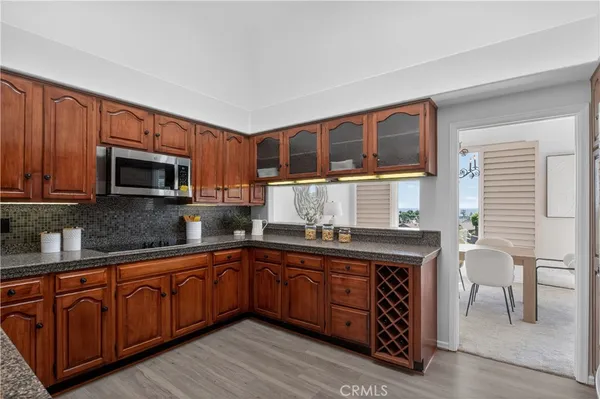a kitchen with stainless steel appliances granite countertop wooden cabinets a stove top oven a sink and dishwasher