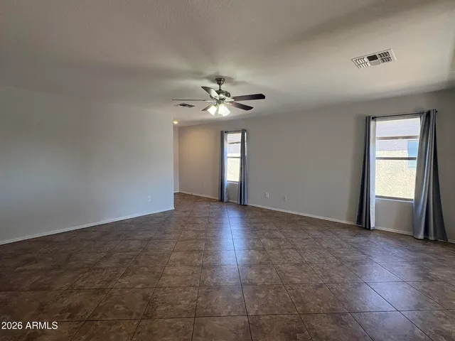 an empty room with fan and windows