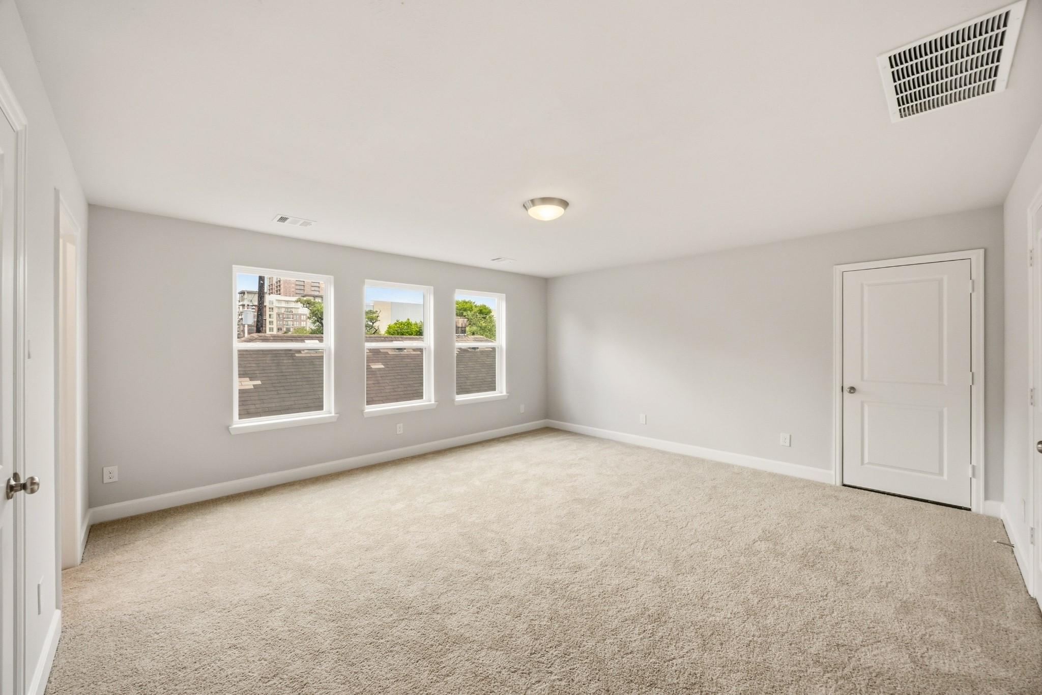4317 Roseland Street, Unit B Houston, TX 77006 - Photo 26 of 29 A remarkably large third-floor bedroom basks in brightness, featuring an ensuite bathroom and access to a substantial walk-in storage closet, ensuring privacy and comfort.