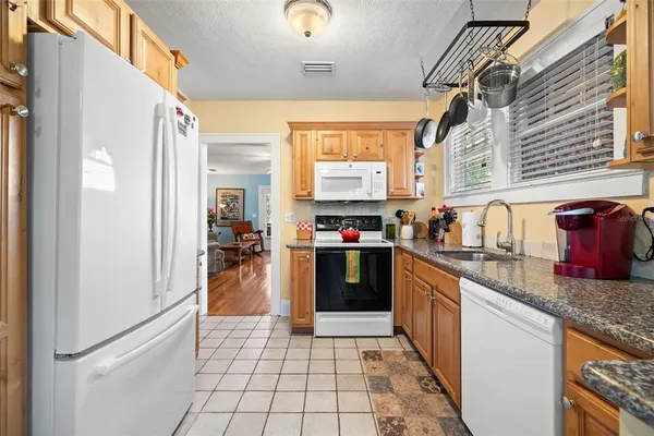 a kitchen with stainless steel appliances granite countertop a refrigerator and a stove