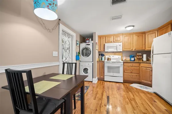 a kitchen with a table chairs refrigerator and cabinets