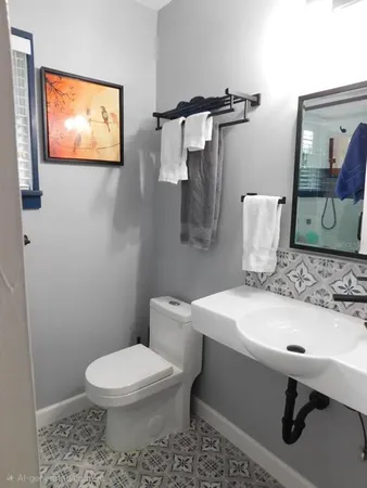 a bathroom with a sink a toilet and mirror