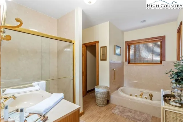 a bath room with a toilet a bath tub and a shower