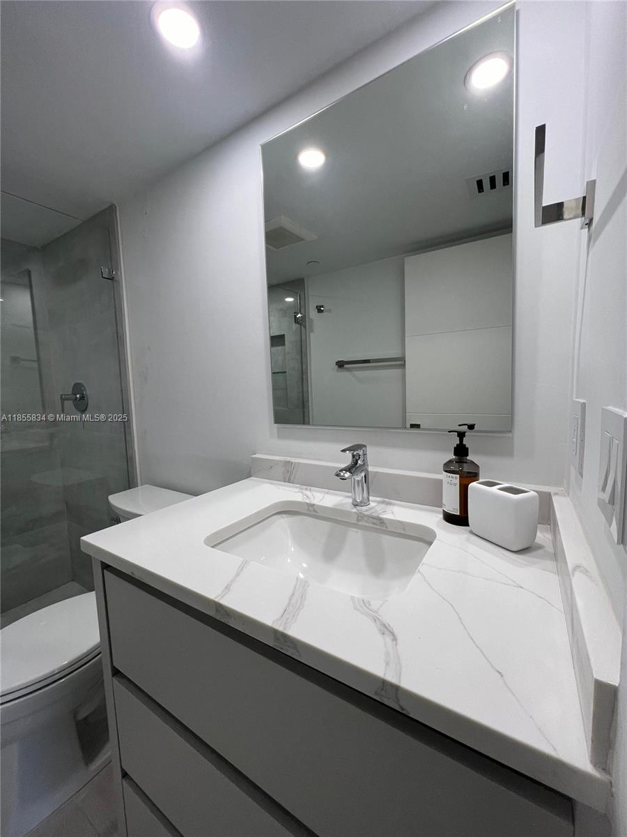 251 Crandon Boulevard, Unit 202 Key Biscayne, FL 33149 - Photo 12 of 24 a bathroom with a sink and a mirror