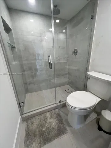 a bathroom with a toilet and a shower