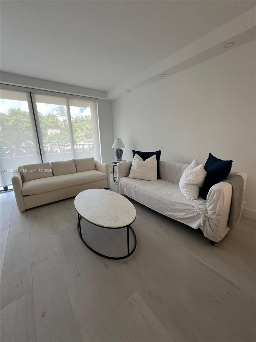 251 Crandon Boulevard, Unit 202 Key Biscayne, FL 33149 - Photo 4 of 24 a living room with furniture and a large window