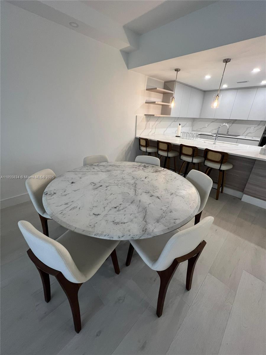 251 Crandon Boulevard, Unit 202 Key Biscayne, FL 33149 - Photo 5 of 24 a living room with stainless steel appliances furniture a rug and a kitchen view