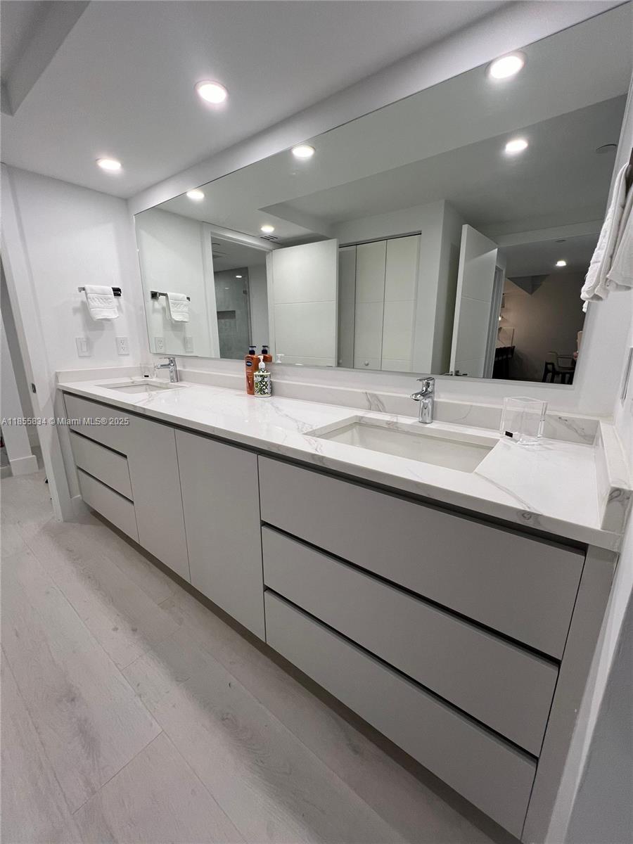 251 Crandon Boulevard, Unit 202 Key Biscayne, FL 33149 - Photo 7 of 24 a bathroom with a double vanity sink and a mirror