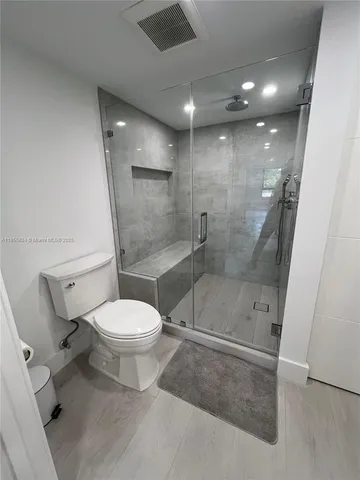 a bathroom with a toilet and a shower
