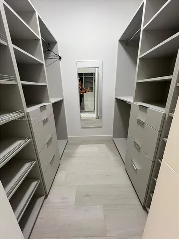 a view of an empty room with a fireplace and cabinets