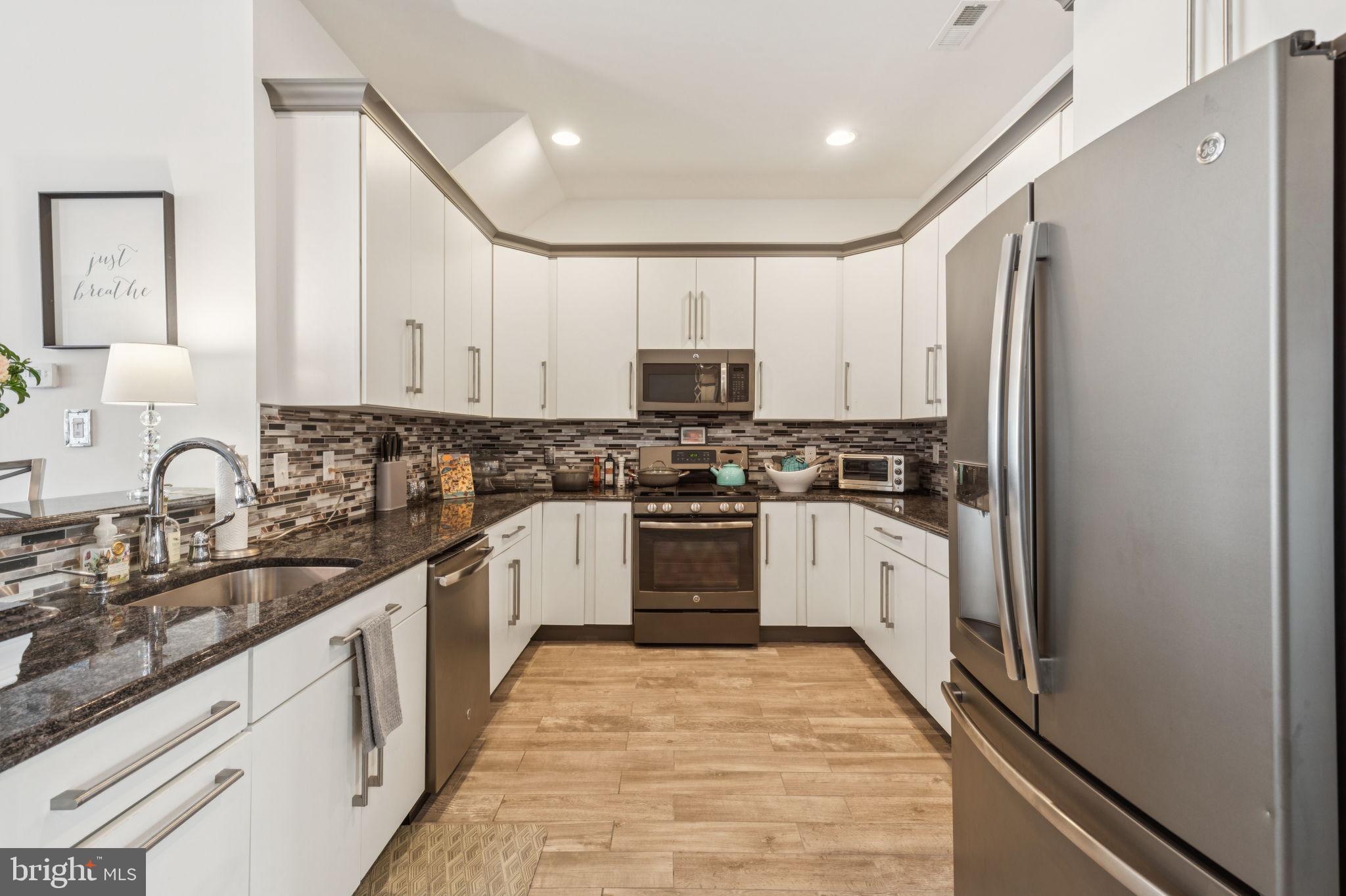 2303 Roma Drive Philadelphia, PA 19145 - Photo 22 of 80 a kitchen with granite countertop white cabinets and stainless steel appliances